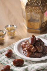 Eating dried dates. Cup of tea on wooden table. Traditional arabic food for iftar