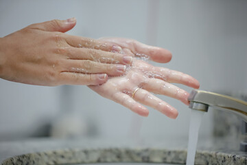 Higienização das mãos lavando num lavabo de um hospital para prevenção do covid-19.