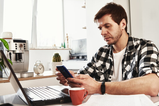 Man works at home office with laptop and documents
