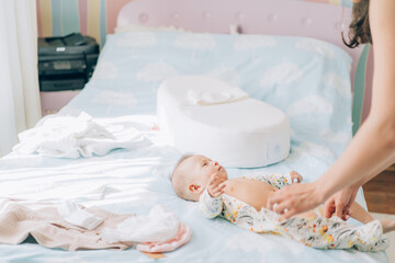 Fototapeta na wymiar Child adoption and In Vitro Fertilization IVF . Asian child lying on the bed. Caring for newborn children