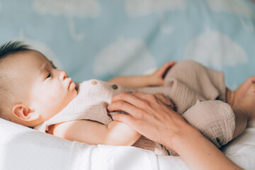 Obraz na płótnie Canvas Child adoption and In Vitro Fertilization IVF . Asian child lying on the bed. Caring for newborn children