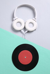 Stereo headphones and vinyl records on gray blue background. 80s. Flat lay. Top view