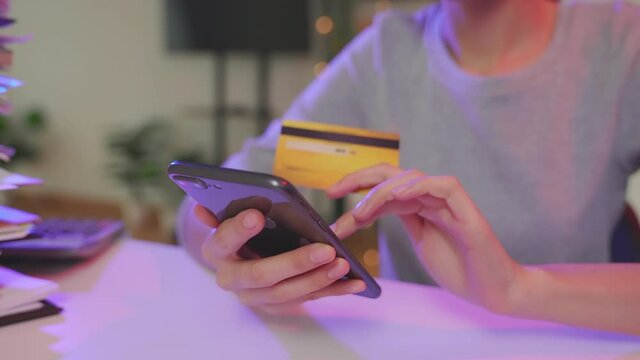 Woman holding smartphone and mock up credit card with paying for shopping online.