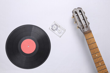 Acoustic guitar neck, vinyl record and audio cassette on a gray background. Musical concept....