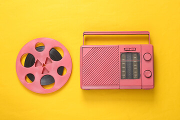 Pink Audio reel and cool radio receiver on yellow background. Musical concept. Top view. Flat lay