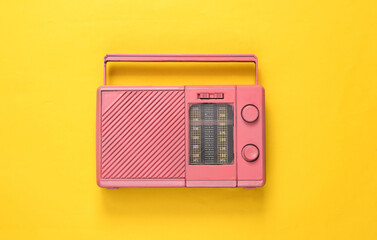 Pink cool radio receiver on yellow background. Minimal Musical concept. Top view. Flat lay