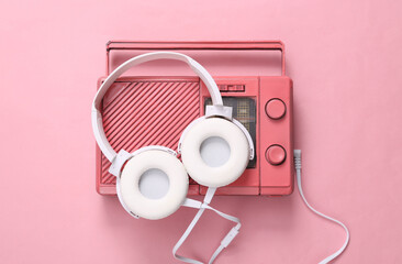 Pink cool radio receiver and headphones on pink background. Minimal Musical concept. Top view. Flat lay