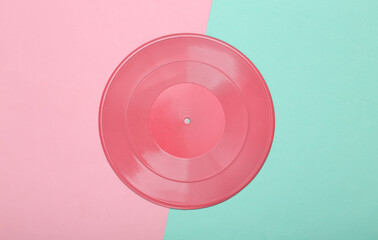 Creative music layout. Pink vinyl record on pink blue background. Minimalism. Flat lay. Top view.