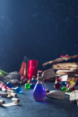 Bottles with colored contents are on the table. small bottles of potions and books of spells and recipes are on the wizard's desk in the smoke
