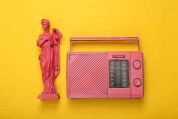 Creative music layout. Pink Antique greek muse statue with radio receiver on yellow background. Inspiration. Minimalism. Flat lay. Top view.