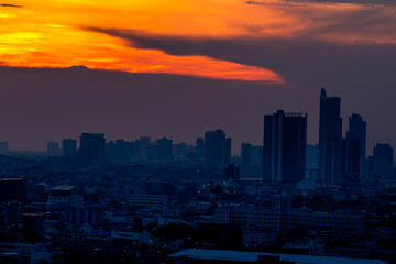 The blurred abstract background of the morning sun exposure to the tiny dust particles that surround the tall buildings in the capital, the long-term health issue of pollution.