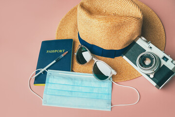 Coronavirus vaccine passport travel essentials : camera, hat, sunglasses, face mask on pink...