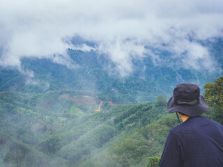 backside of traveler enjoying beautiful nature of hills and  morning mist.