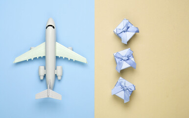 Air delivery. Plane figurine and gift boxes on yellow blue pastel background. Flat lay. Top view