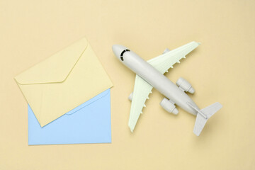 Air mail, air delivery. Flat lay composition with an airplane figure and envelopes of letters on yellow background. Top view