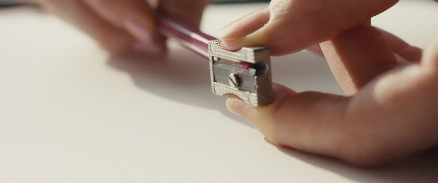 Pencil sharpener in woman's hand fingers macro close up slow motion