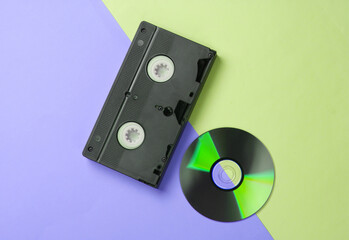 Flat lay composition of cd disc, audio cassette on colored background. Retro storage media. Top view