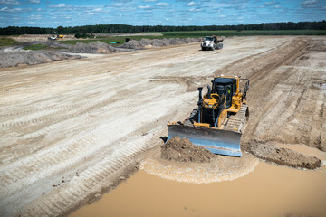 A D6T dozer pushing material off the end of a lift into a puddle of water.  Bridging over the water...