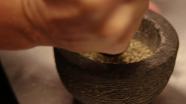 Chef de Partie crushing pepper in a