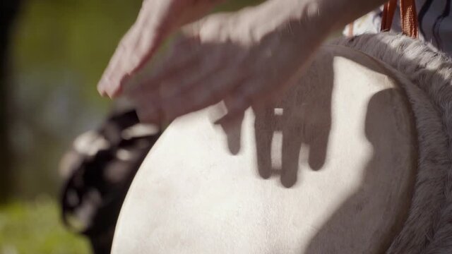 A close up of a conga drum played in slow motion.