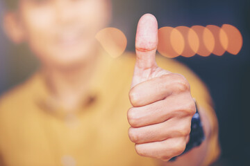 Close up  of Businessman showing thumbs up sign in office at his workplace. Selected focus