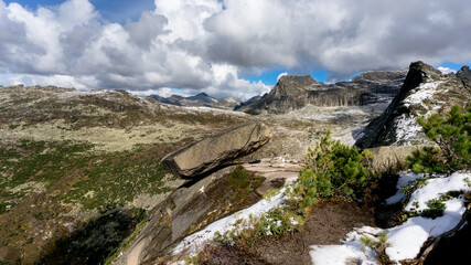 A large stone at the cliff of the mountain hangs in the bottom Hanging stone Natural Park Ergaki cloudy in summer