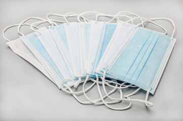 Stack of surgical mask to protect against germs on gray background