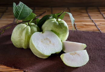Fresh Guava fruits on napery and on brown tabl mat Thai fruit.