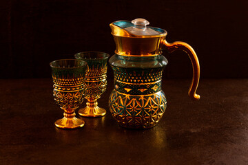Antique tea set in gold color isolated on dark background
