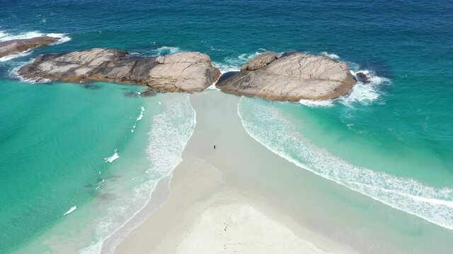 2020 - Excellent aerial shot of a tourist standing among white sand and clear blue surf in Wylie Bay, Esperance, Australia.