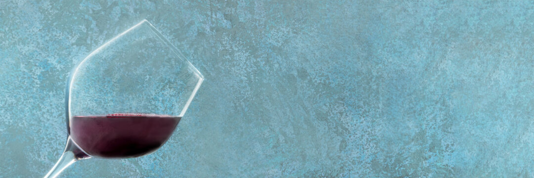 Red wine panorama. A wineglass on a blue background with a place for text