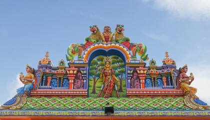 Fototapeta na wymiar Indian traditional Goddess Mariyamman statue on temple tower 