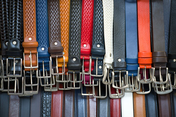 Hanging multi-colored leather belts close-up