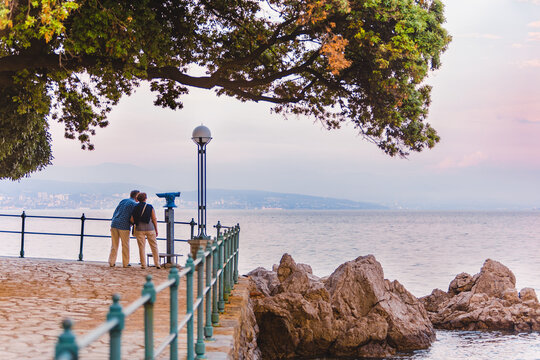 Opatija, Croatia - June 4, 2019: senior couple walking by city quay