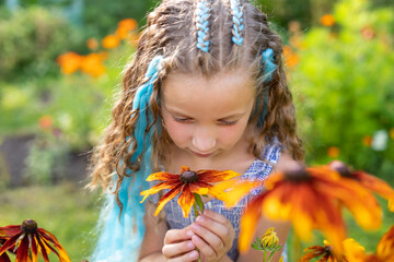 Brunette long hair girl in the garden. Braided hair with blue kanekalon. hairstyle braiding.Teenage girl with Fashionable colored blue pigtails.little girl with braids.