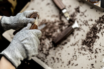 Woman working in carving spoon at home, close up in hands