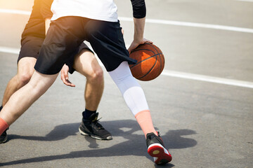Naklejka premium Young guys are playing street basketball.