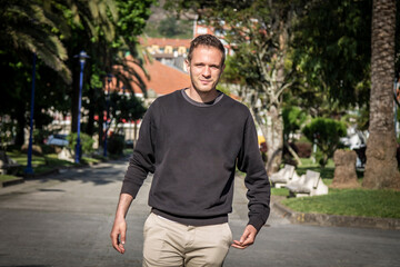 portrait of young man walking in the park on the walk