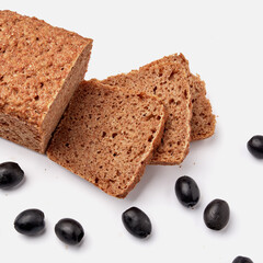 sliced rye bread on a white plate with  olives