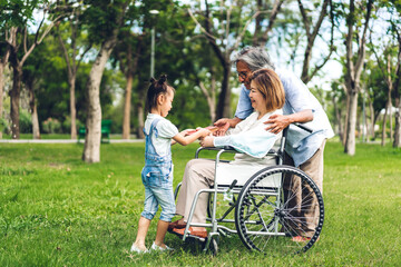 Obraz premium Portrait of happy asian grandfather with grandmother and asian little cute girl enjoy relax in summer park.Young girl with their laughing grandparents smiling together.Family and togetherness