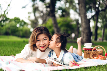 Portrait of happy asian grandmother and little asian cute girl enjoy relax in summer park.Young girl with their laughing grandparents smiling together.Family and togetherness