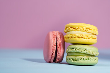 French dessert macaron on pink and blue background. Modern Macarons on colorful background. copy space.