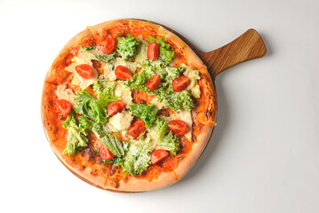 Caesar pizza isolated on white background. Italian pizza with caesar salad filling.