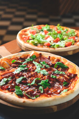 Fresh tasty pizza served on a wooden table in restaurant or diner over blurred background.
