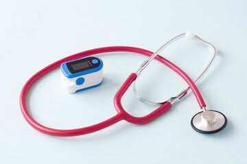 Pulse Oximeter, finger digital device to measure person's oxygen saturation and a stethoscope. Reduced oxygenation is an emergency sign of pneumonia caused by flu or novel coronavirus.