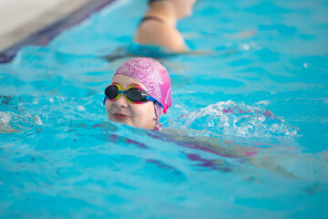 Fototapeta na wymiar Child athlete swims in the pool. Swimming section.