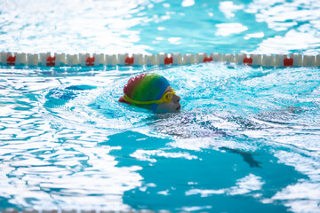 Child athlete swims in the pool. Swimming section.