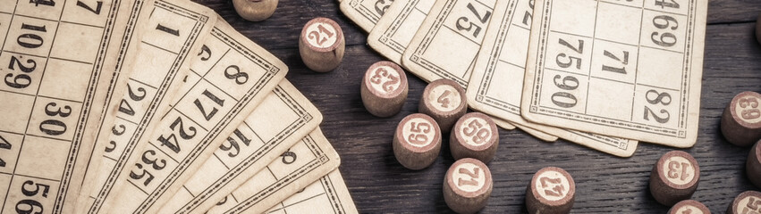 Cards and lotto kegs on a wooden background in vintage style banner