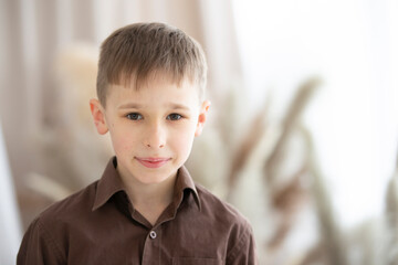 A boy of nine or ten years of European appearance is looking at the camera.