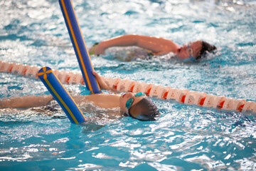 Child athlete swims in the pool. Swimming section.